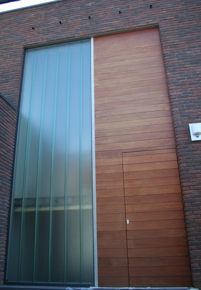 Porte d'entrée en bois massif dans l'habillage de façade